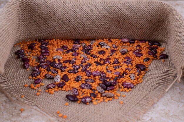 Délicieuses lentilles et haricots dans un bol en bois sur une surface en marbre.