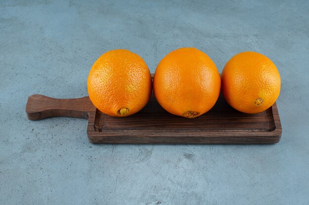 Délicieuses oranges sur une planche, sur fond de marbre. photo de haute qualité