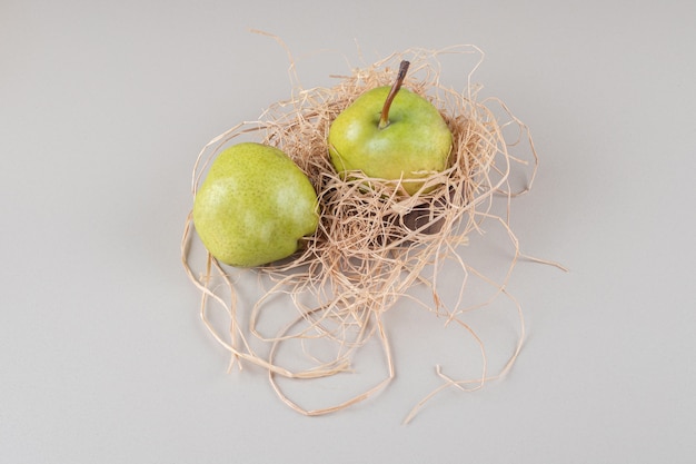 Délicieuses poires sur un petit tas de paille sur marbre