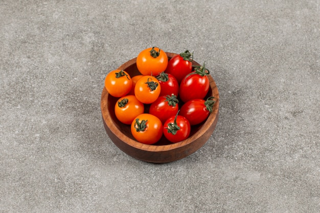 Délicieuses tomates dans le bol, sur le marbre.