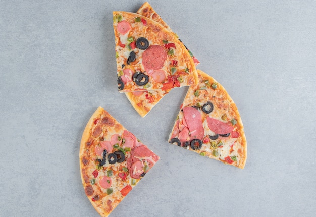 Photo gratuite délicieuses tranches de pizza empaquetées sur du marbre