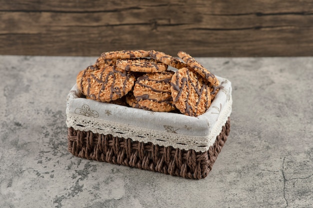 Délicieux biscuits multigrains frais avec glaçage au chocolat dans le panier.