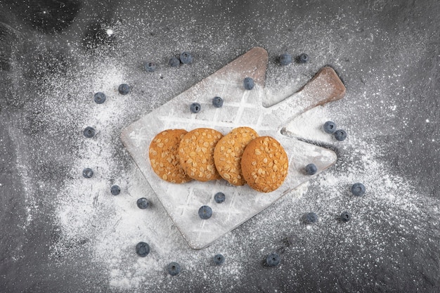 Photo gratuite délicieux biscuits sucrés sur planche de bois aux bleuets