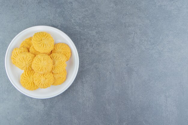 Délicieux biscuits sucrés sur plaque blanche.