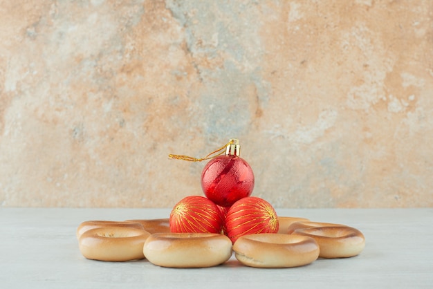 Délicieux biscuits sucrés ronds avec des boules de Noël rouges sur fond blanc. Photo de haute qualité