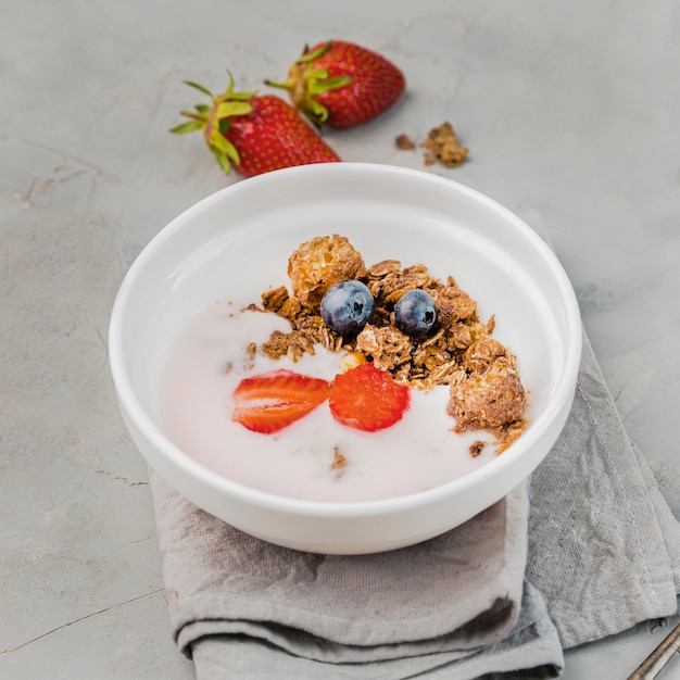 Photo gratuite délicieux bol de petit déjeuner avec granola et fraise