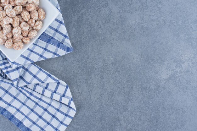 De délicieux bonbons à la cannelle dans l'assiette, sur le fond de marbre.