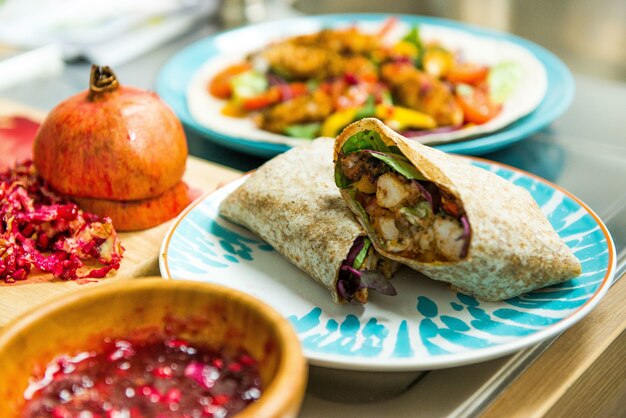 Délicieux burrito mexicain avec légumes et poulet frit signifie sur une assiette