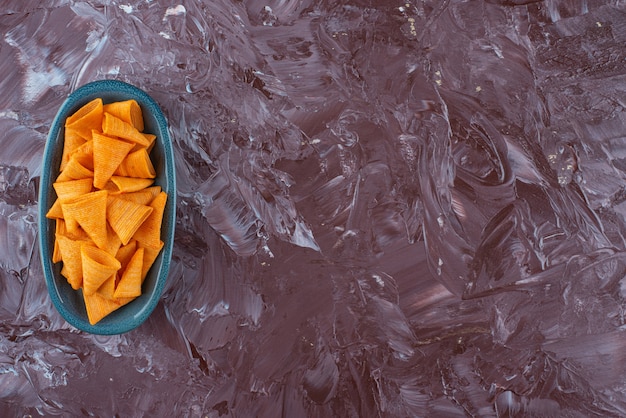 De délicieux chips de cône dans une assiette, sur la table en marbre.