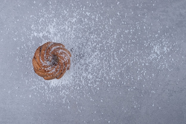 Délicieux cookie sur un tas de poudre de vanille sur une surface en marbre