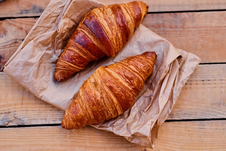 Photo gratuit délicieux croissant croustillant sur un bureau en bois.image en gros plan