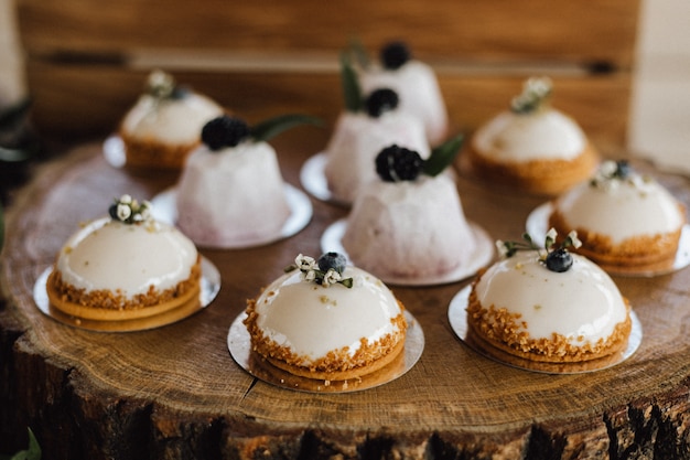 Délicieux desserts crémeux décorés sur le plateau en bois