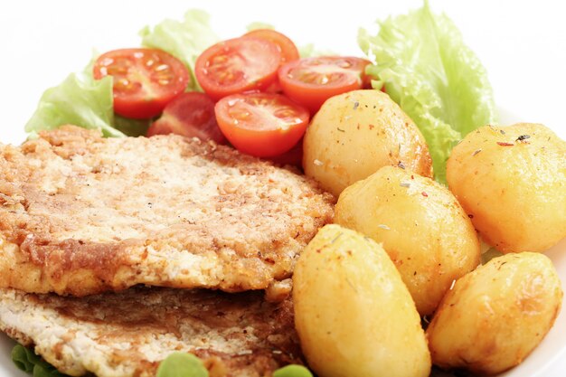 Délicieux dîner avec steaks, pommes de terre bouillies et salade