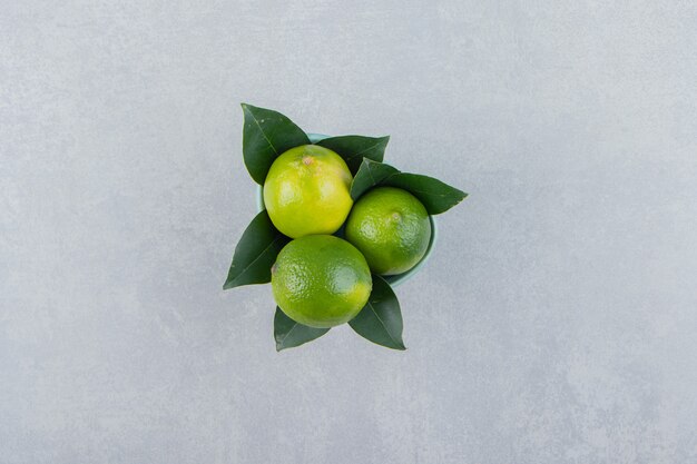 De délicieux fruits de citron vert dans un bol bleu.