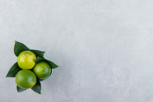 De délicieux fruits de citron vert dans un bol bleu