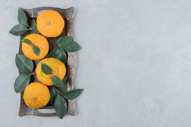De délicieux fruits de mandarine sur un plateau en métal