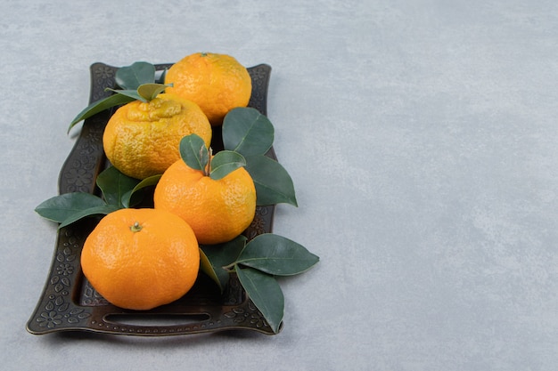 De délicieux fruits de mandarine sur un plateau en métal