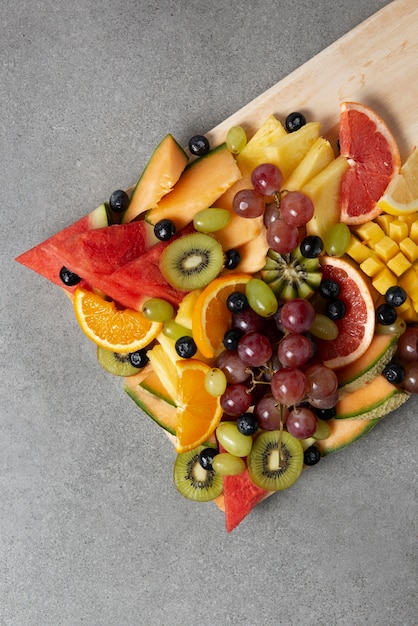 Photo gratuite délicieux fruits sur planche de bois vue de dessus