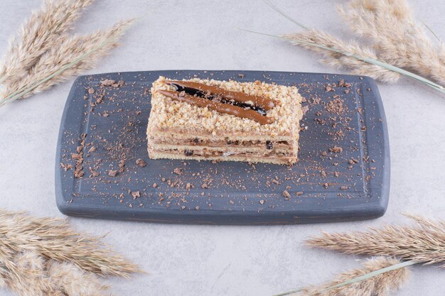 Délicieux gâteau sur une assiette sombre avec des épis de blé.