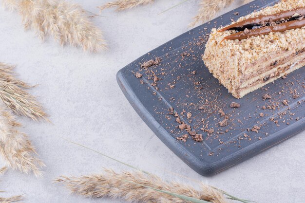 Délicieux gâteau sur une assiette sombre avec des épis de blé.