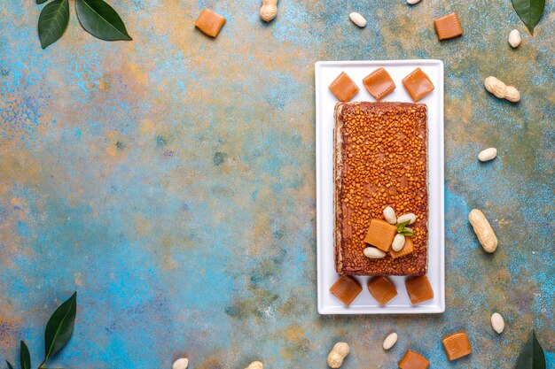 Délicieux gâteau au caramel et aux arachides avec cacahuètes et bonbons au caramel, vue du dessus