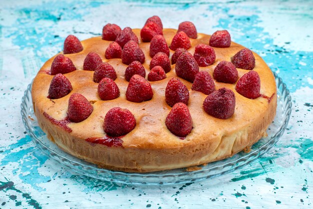 Délicieux gâteau aux fraises en forme de rond avec des fruits sur le dessus sur bleu vif, pâte à gâteaux sucre biscuit sucré