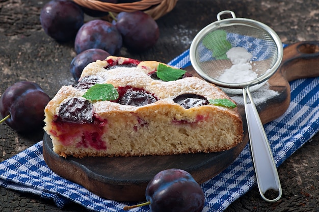 Délicieux gâteau fait maison avec des prunes sur un bois