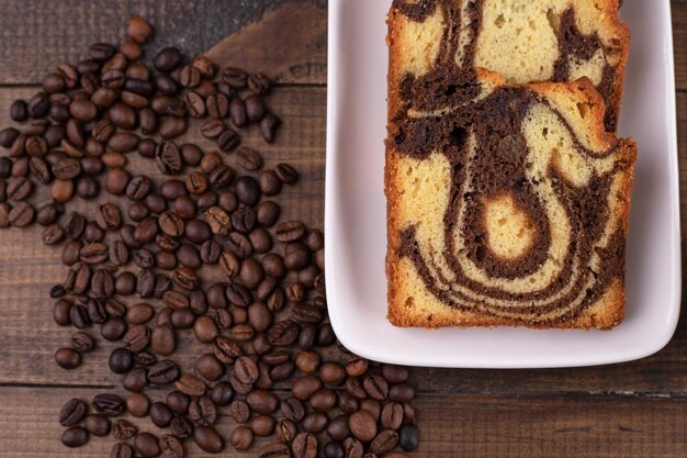 Délicieux gâteau frais dans une assiette blanche avec des grains de café.