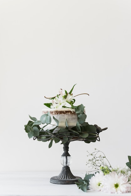 Délicieux gâteau de mariage décoré de fleurs sur fond blanc