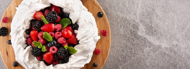 Photo gratuite délicieux gâteau pavlova garni de meringue et de baies fraîches