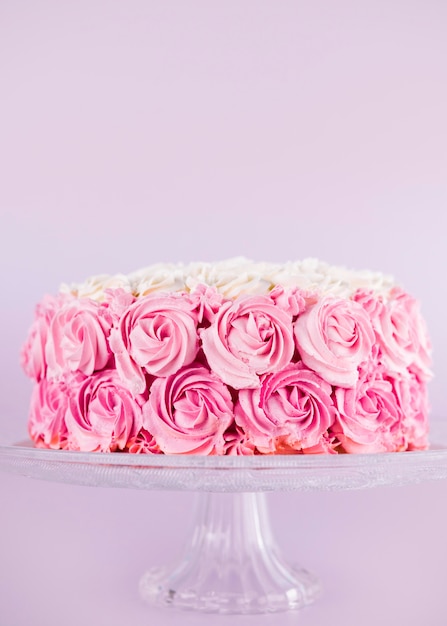 Délicieux gâteau rose avec des roses sur le stand