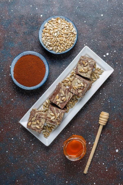 Délicieux halva en marbre avec des graines de tournesol, de la poudre de cacao et du miel, vue de dessus