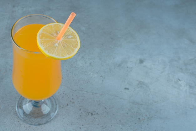 Délicieux jus d'orange avec tranche de citron et paille.