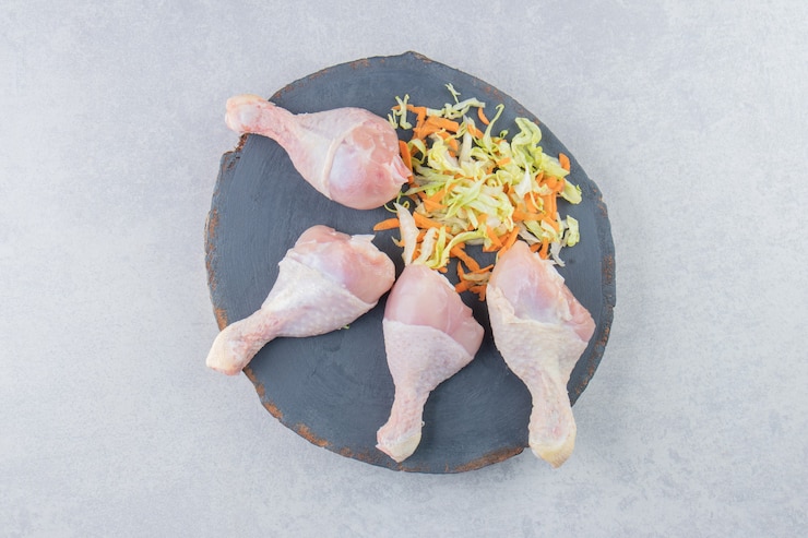 Photo gratuit délicieux légumes verts et cuisses de poulet sur la planche, sur la surface blanche