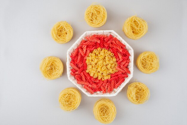 Délicieux macaronis crus colorés sur plaque