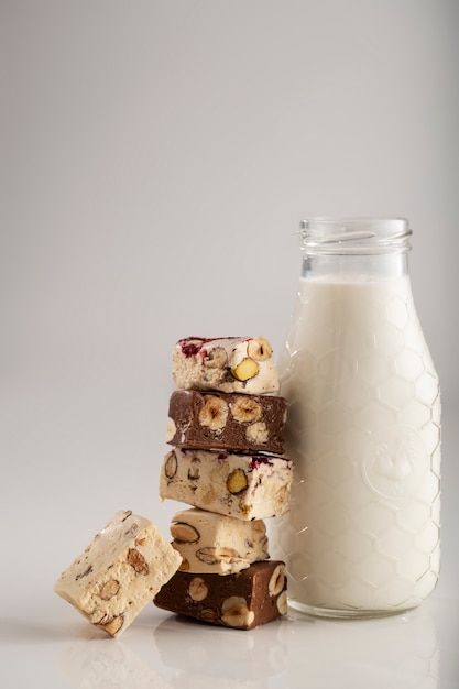 Photo gratuite délicieux nougats et bouteille de lait