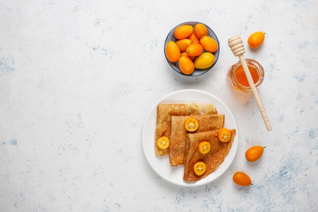 Délicieux petit déjeuner. Fête orthodoxe Maslenitsa. Crêpes avec cumquats et honet, vue de dessus