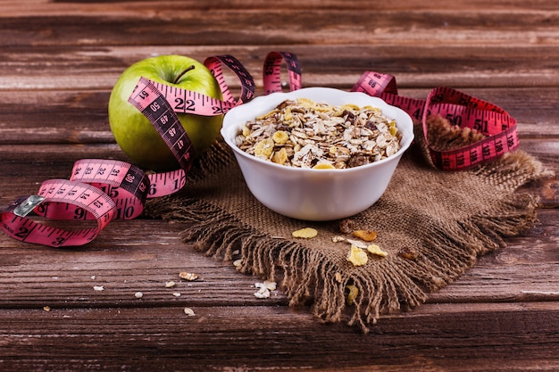 Délicieux petit-déjeuner sain fait de lait et de porridge avec des noix, des pommes et des bananes