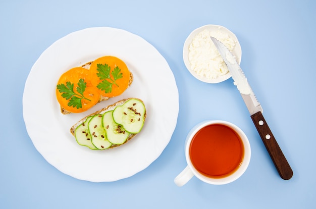 Délicieux petit déjeuner avec des sandwichs végétariens et une tasse de tee