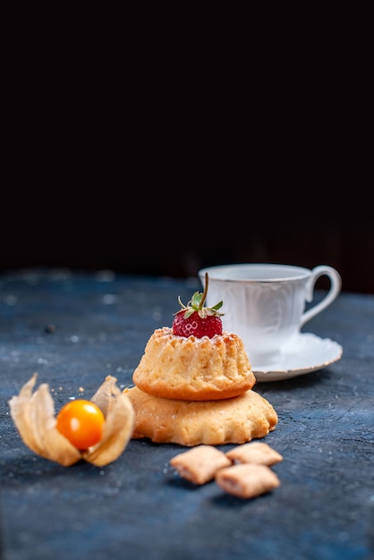 Délicieux petit gâteau avec une tasse de café sur fond noir, gâteau biscuit sucre sucré cuire le café