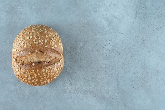 Délicieux petit pain aux graines sur marbre.