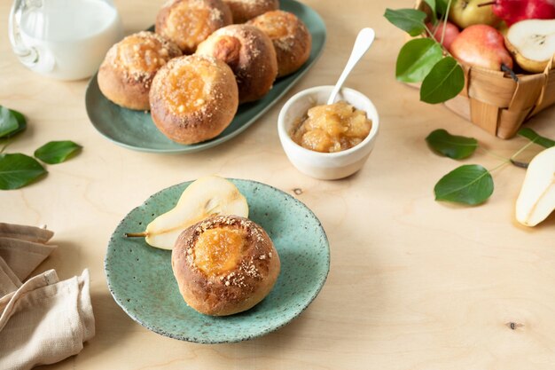 Délicieux petits pains faits maison avec de la confiture et des poires fraîches sur un fond en bois Mini tartes Recette de cuisine