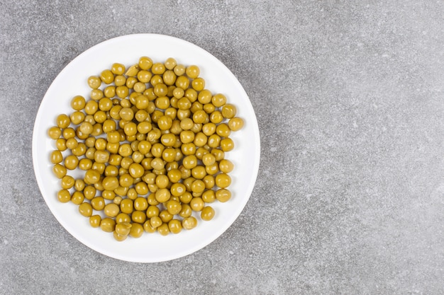 Délicieux pois en conserve sur plaque blanche