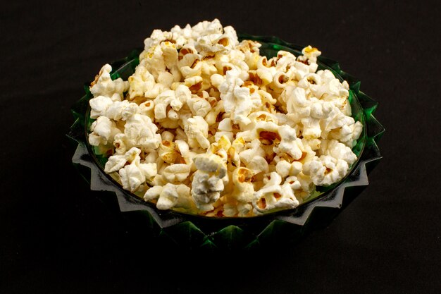 Délicieux pop-corn savoureux délicieux salé à l'intérieur d'une assiette ronde sur un fond sombre