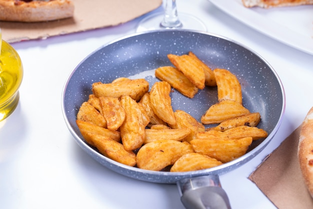 Photo gratuite délicieux quartier de pommes de terre maison croustillantes frites dans la poêle