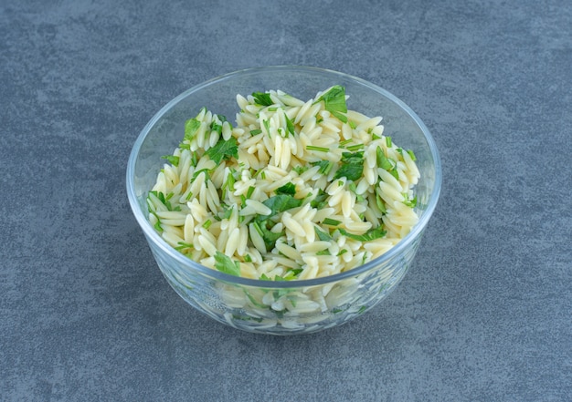 Délicieux riz aux légumes verts dans un bol en verre.