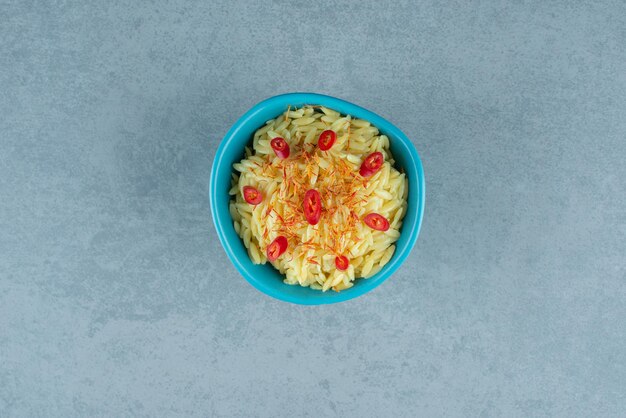 Délicieux riz aux tranches de tomates dans un bol bleu.