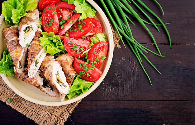 Délicieux rouleaux de poulet farcis au fromage et aux épinards enveloppés de lardons. Vue de dessus