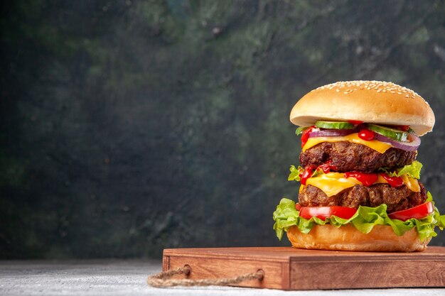 Délicieux sandwich maison sur planche de bois attaché avec une corde sur une surface floue