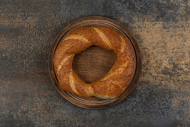 Délicieux simit aux graines de sésame sur plaque en bois